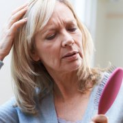 Mature Woman With Brush Corncerned About Hair Loss