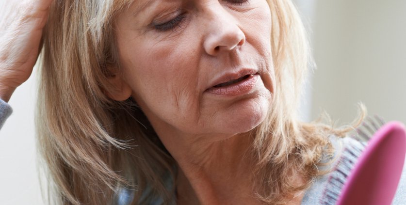 Mature Woman With Brush Corncerned About Hair Loss