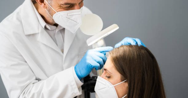 hair doctor examining a female patient's hair